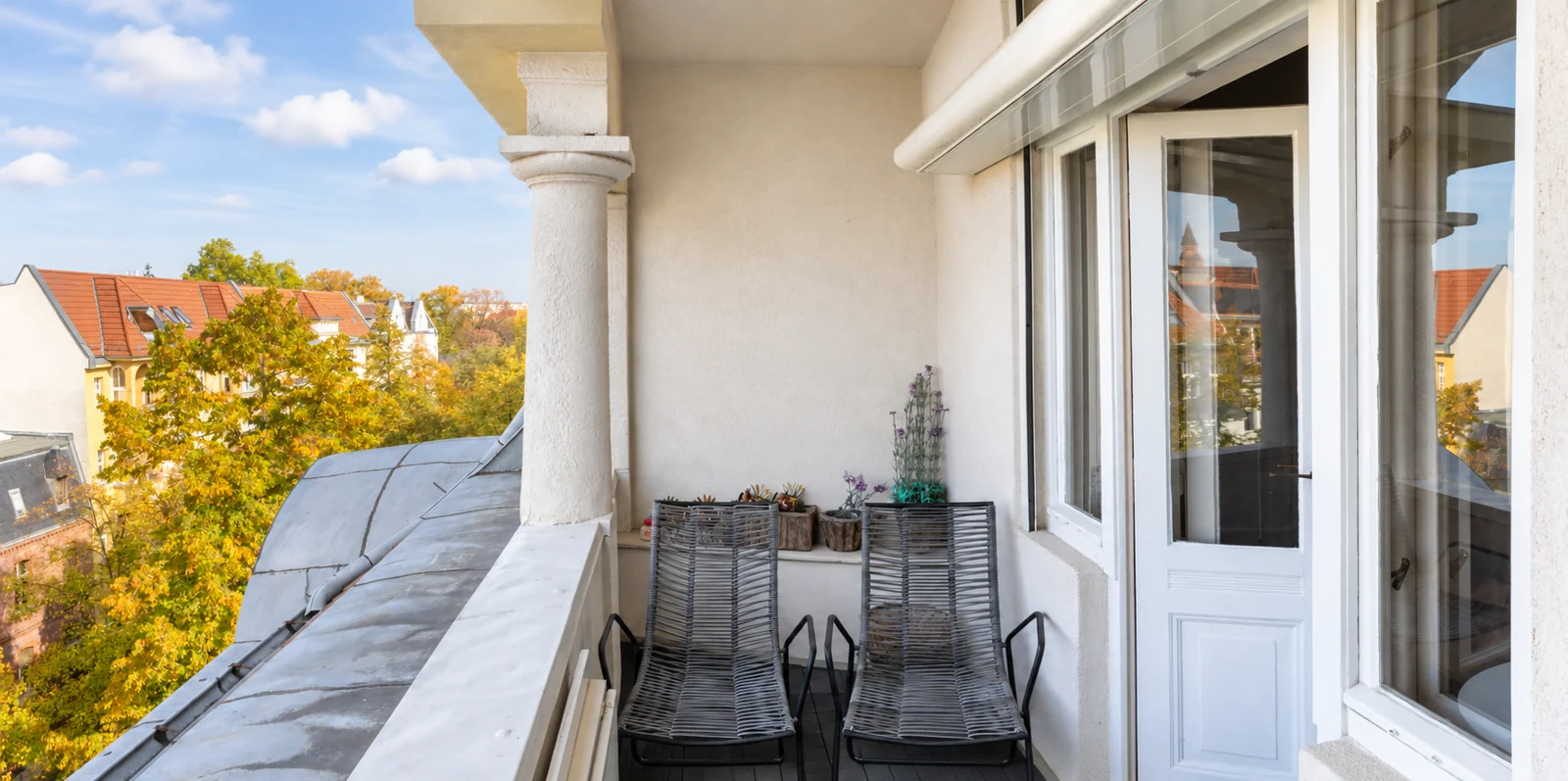 Überdachter Balkon mit Säulen, Sitzplätzen und Blick ins Grüne